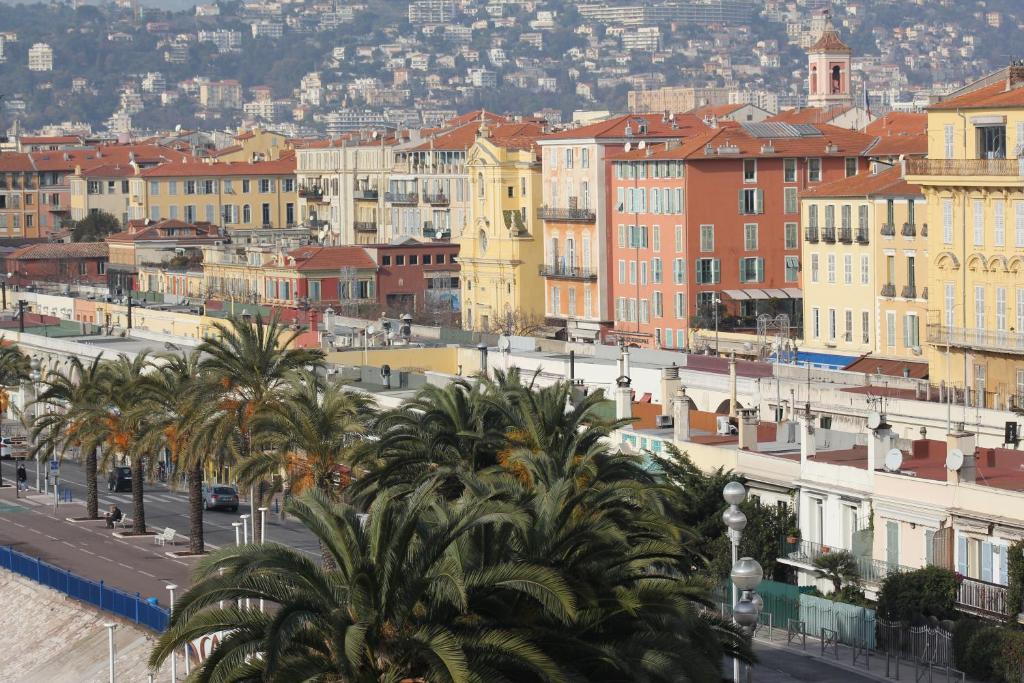 a city with buildings and palm trees and a street at Hotel Suisse in Nice