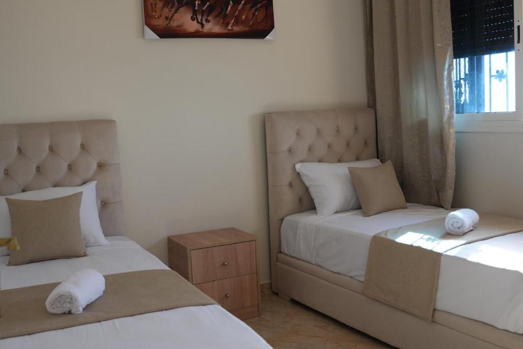 a bedroom with two beds and a window at Apartamentos de Fola 3 in Asilah