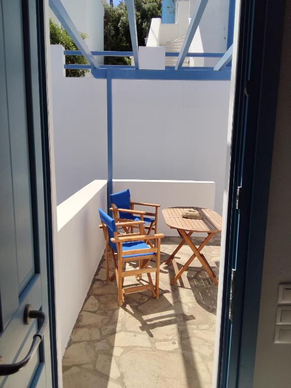 a balcony with two chairs and a table at Andros Guesthouses in Andros