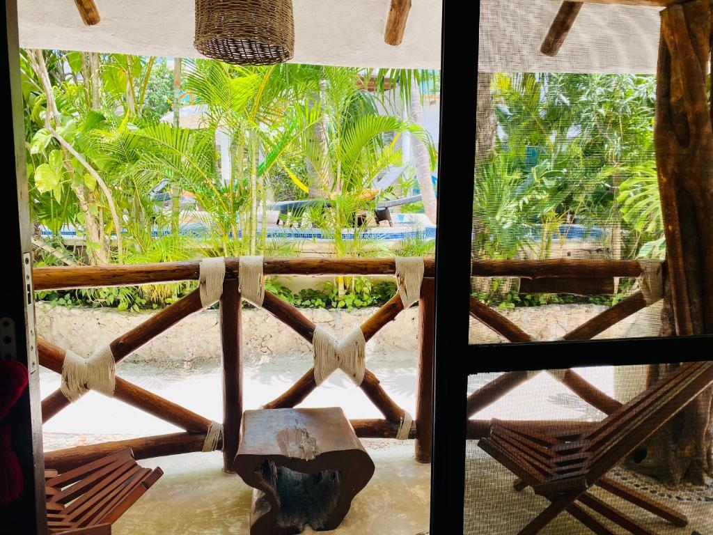 a room with a view of a beach and palm trees at Hotel Para Ti - Adults Only in Holbox Island