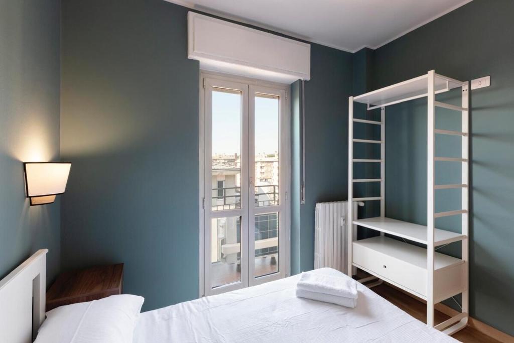 Un dormitorio con una cama blanca y una ventana. en Sweet Green Apt Tortona District, en Milán