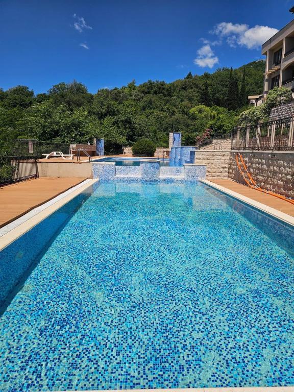a large swimming pool with blue water at Adria Montenegro Apartment in Tušupi