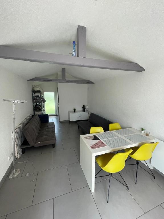 un salon avec une table et des chaises jaunes dans l'établissement Le Megève, à Sainte-Croix-en-Plaine