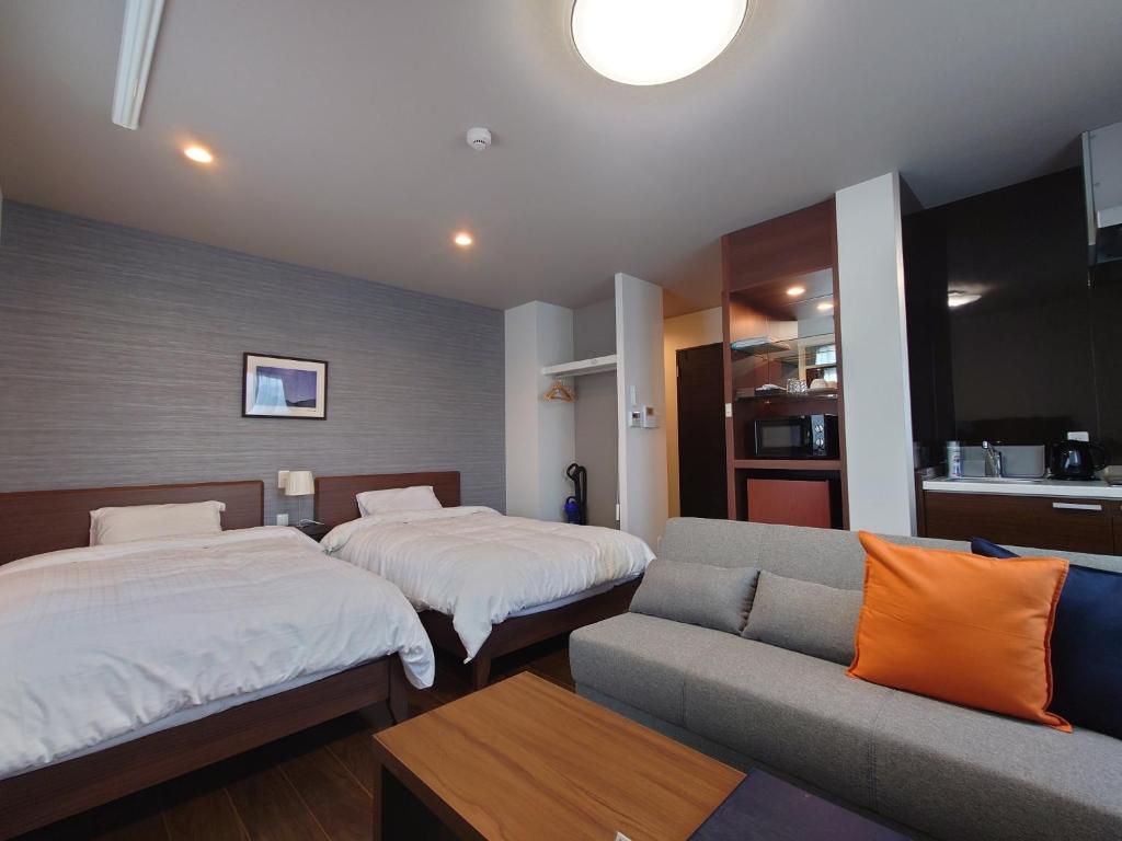 a hotel room with two beds and a couch at SA Inn Ina Nice Road - Vacation STAY 31748v in Ina