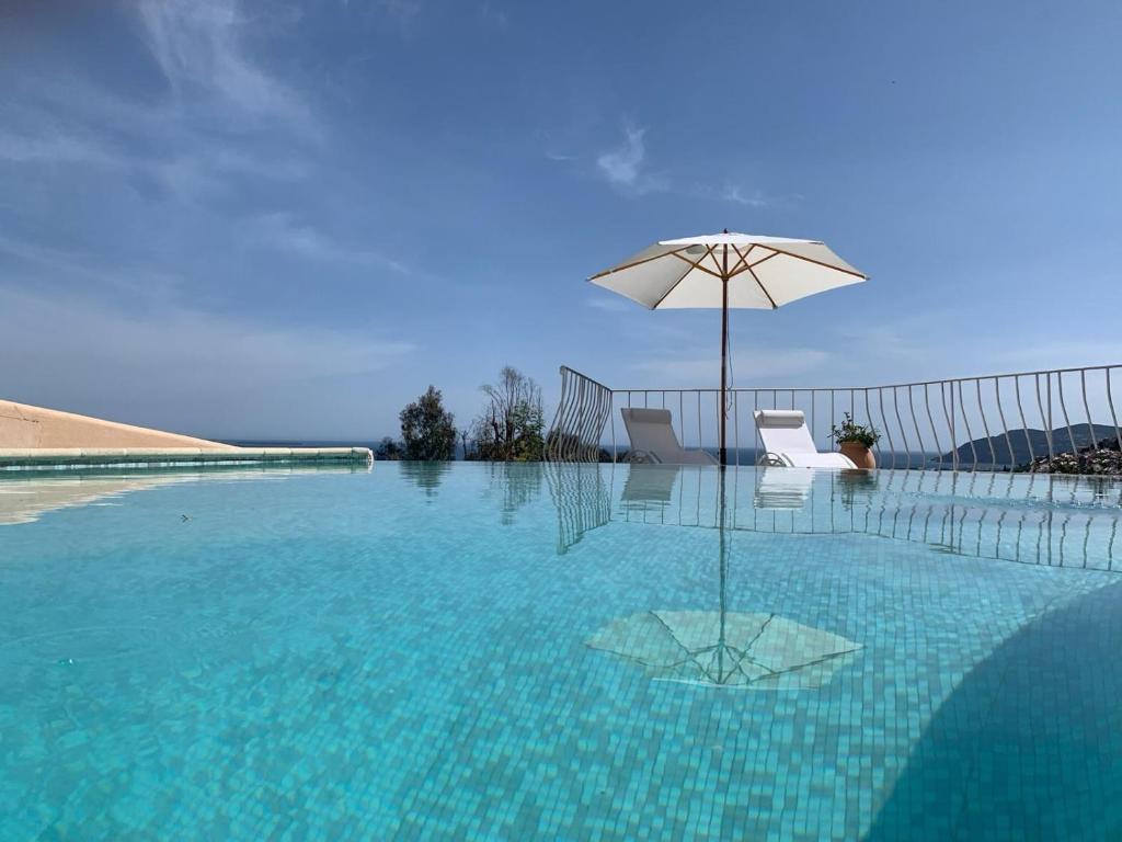 - une piscine avec un parasol, une chaise et une table dans l'établissement Villa la Roche Cannes, Meerblick, Salzwasserpool, Sauna, à Mandelieu-la-Napoule