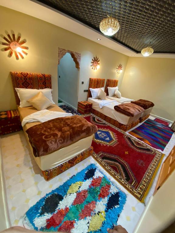 a bedroom with two beds and a rug at Agafay Toubkal View in Imlil