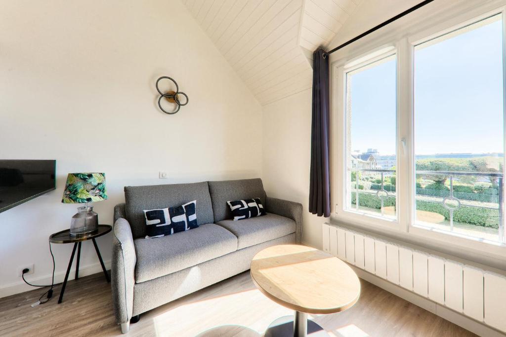 un salon avec un canapé et une grande fenêtre dans l'établissement Résidence Port du Crouesty - maeva Home - Appartement bord de mer 4 pièces 5 personnes - Prestige - super Home MAE-9403, à Arzon
