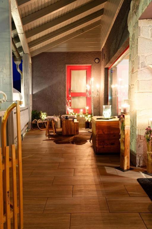 a living room with a wooden floor and a red door at Lord Michael Chalet in Bodenmais