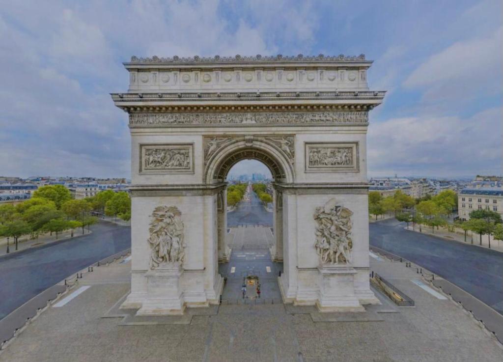 un grand monument avec une arche dans une ville dans l'établissement studio Champs Elysees, à Paris