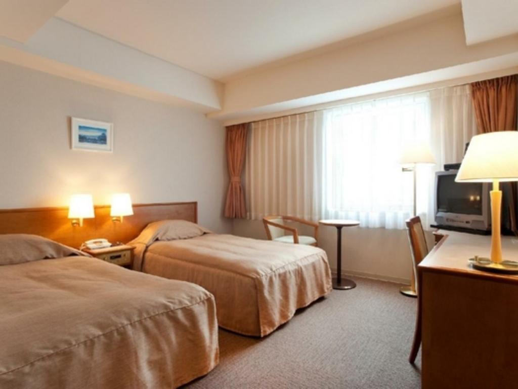 a hotel room with two beds and a television at Hotel Okhotsk Palace - Vacation STAY 24138v in Mombetsu