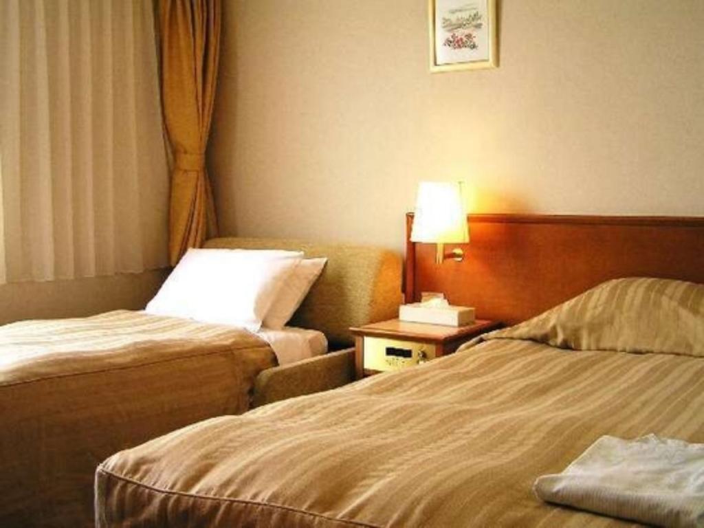 a hotel room with two beds and a lamp at Hotel Okhotsk Palace - Vacation STAY 24148v in Mombetsu