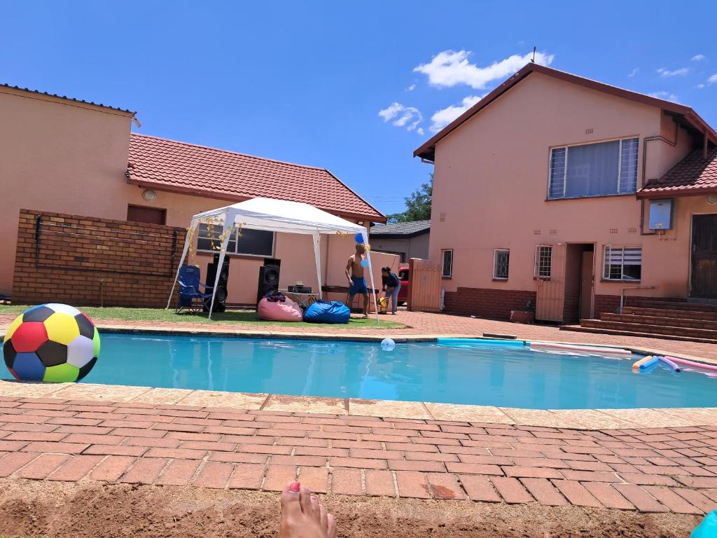 a person standing next to a swimming pool with a ball at Hideaway in Roodepoort