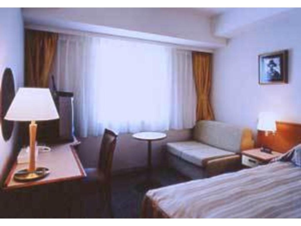 紋別市にあるHotel Okhotsk Palace - Vacation STAY 24136vのベッドとソファとテーブルがあるホテルの部屋