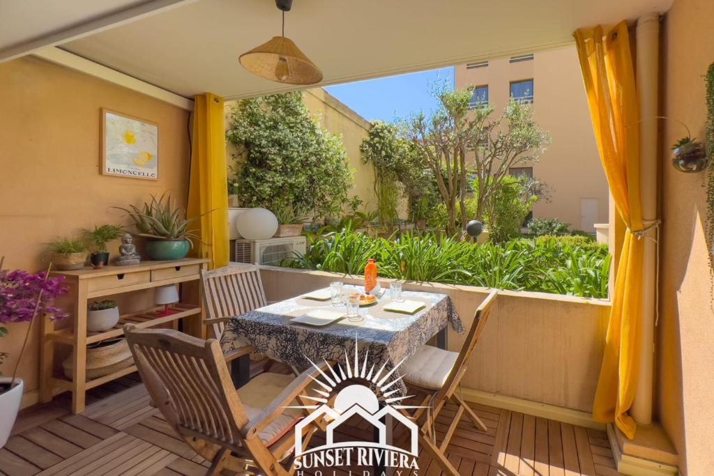 un patio avec une table et des chaises sur un balcon dans l'établissement LE PATIO VAUBAN Airco Garage for 4 by SUNSET, à Antibes