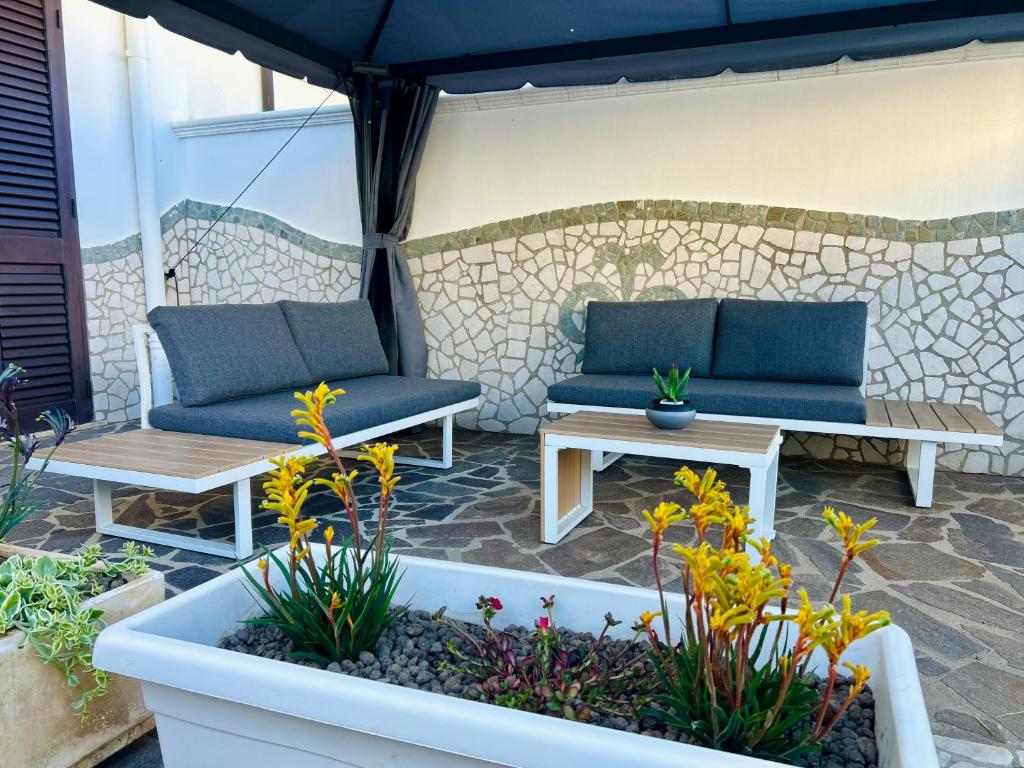 a patio with two blue couches and a table at Blue Marine Affitta Camere in Porto Cesareo