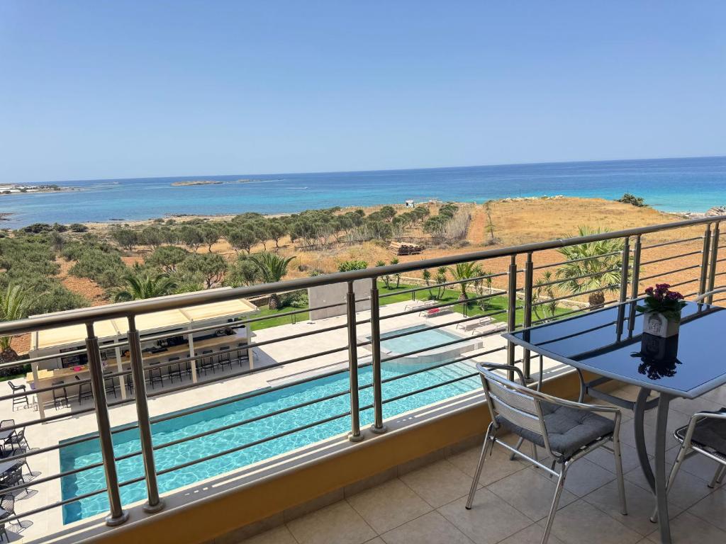 a balcony with a table and chairs and the ocean at Pachia Ammos Falasarna in Falasarna