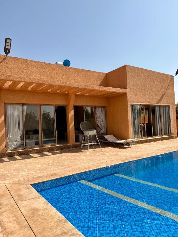 マラケシュにあるThe Atlas View and Elegant Villa Marrakechの家の前にプールがある家
