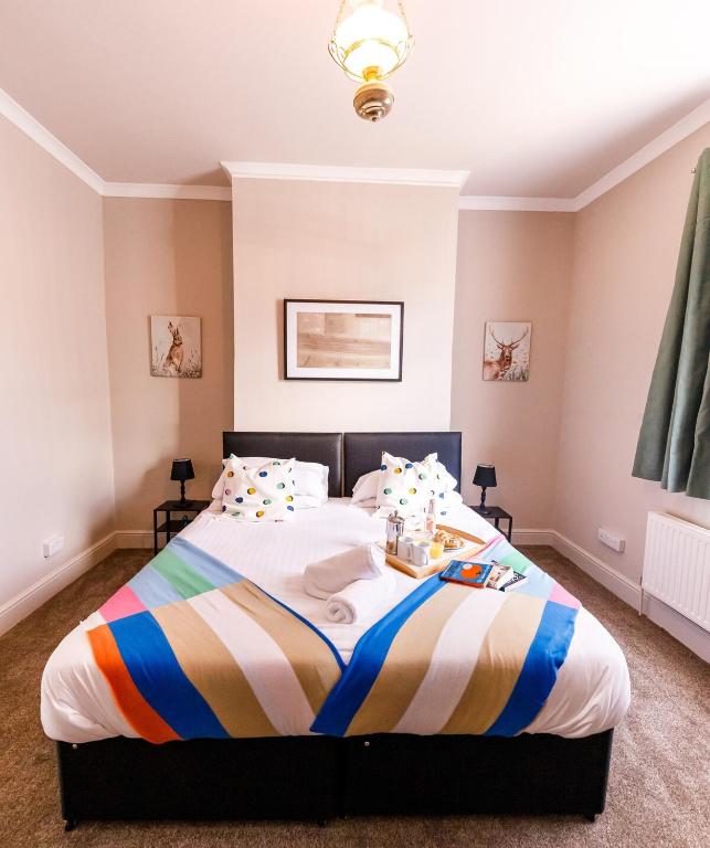 a bedroom with a bed with a striped blanket at Spacious 4Bed Parking & Wi-Fi - Contractor Stays in Pallion