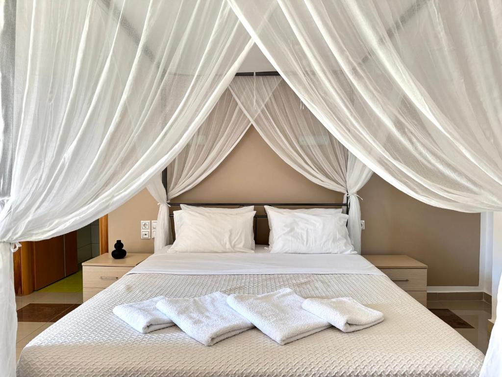 a bedroom with a canopy bed with two white towels at Pachia Ammos Falasarna in Falasarna