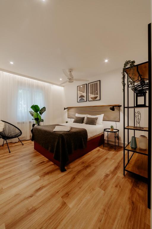a bedroom with a large bed and wooden floors at Logroño Urban Home in Logroño