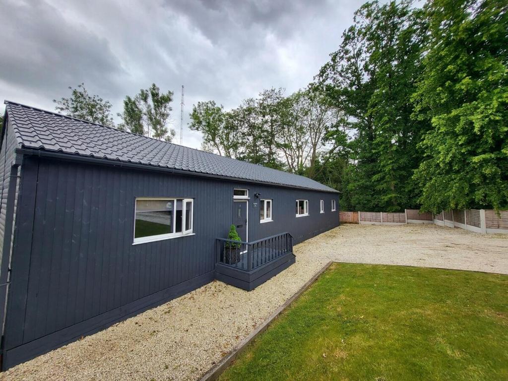 a blue building with a yard in front of it at Woodland View Retreat - Luxury Stay, Endless Fun in Upton Warren