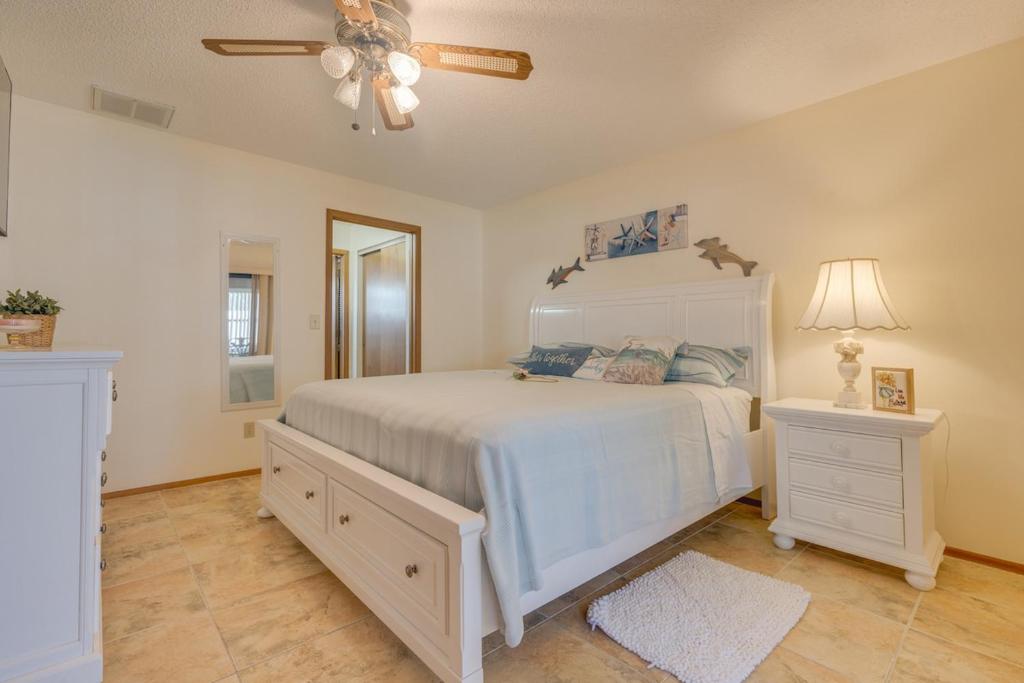 a bedroom with a white bed and a ceiling fan at Private Suite with Full Kitchen 5 ml to Beach in Clearwater