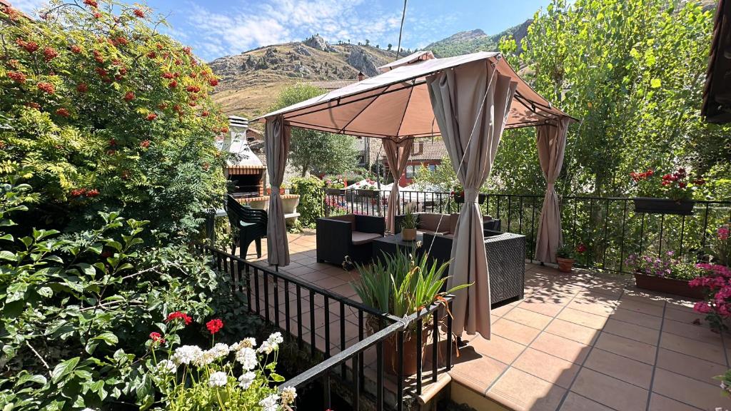 un patio con cenador y algunas flores en El Hayedo de Argovejo, en Argovejo