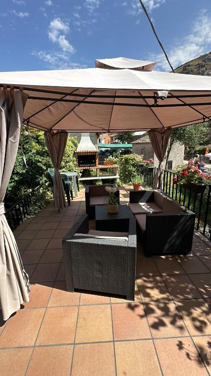 un patio con sombrilla, mesa y sillas en El Hayedo de Argovejo, en Argovejo