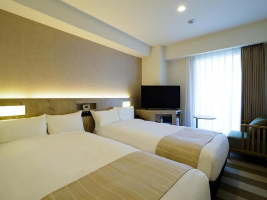 横浜市にあるFar East Village Hotel Yokohama - Vacation STAY 27932vのベッド2台と薄型テレビ付きのホテルの部屋