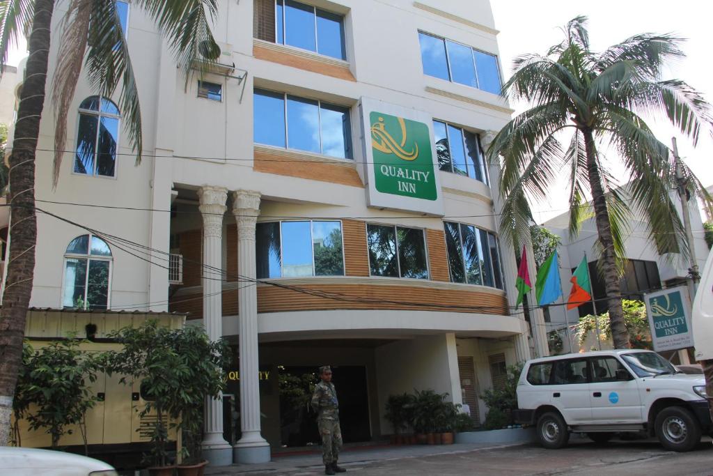 un homme debout devant un bâtiment dans l'établissement Quality Inn Dhaka, à Dhaka