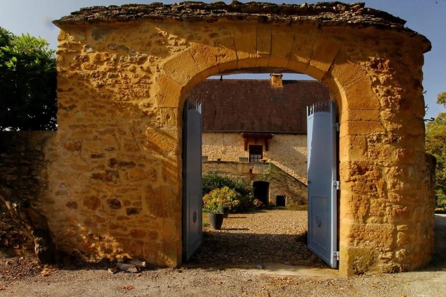 - une entrée pour un bâtiment en pierre avec deux portes dans l'établissement Piscine, Charme et Calme au coeur du Périgord, à Finsac