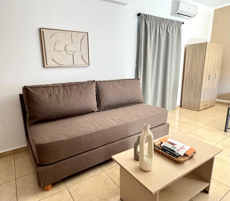 a living room with a brown couch and a table at Pachia Ammos Falasarna in Falasarna