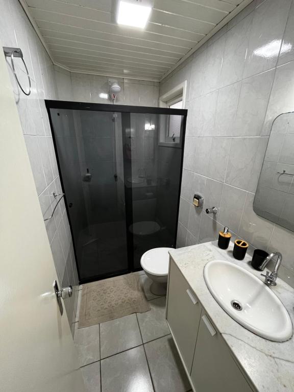 a bathroom with a shower and a toilet and a sink at AP 100m do mar mesma rua do Quiosque VavaZão in Capão da Canoa