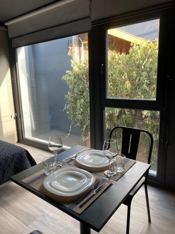 a table with two plates and wine glasses on it at Edificio Pantera - monoambiente 13 in San Martín de los Andes