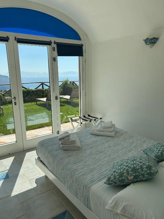 una camera da letto con un letto con vista sull'oceano di The little tower of Minuta a Scala