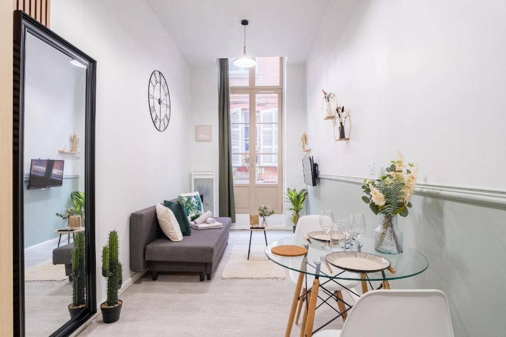 un salon avec un canapé et une table dans l'établissement Le Petit Boulbone, à Toulouse