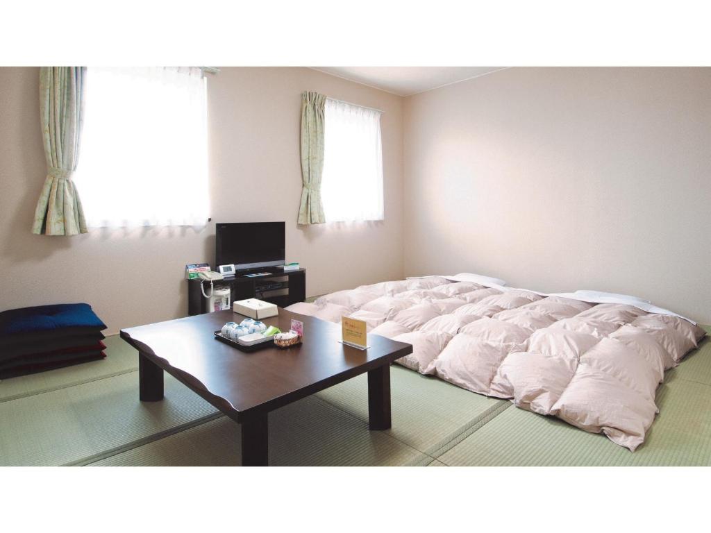 a large bed in a room with a table at Hotel New Ohte - Vacation STAY 32404v in Hakodate
