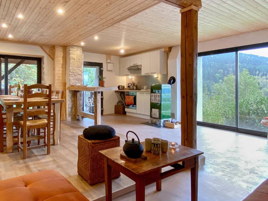 a living room with a table and a kitchen at Gîte Les Ebeteux in Fraize
