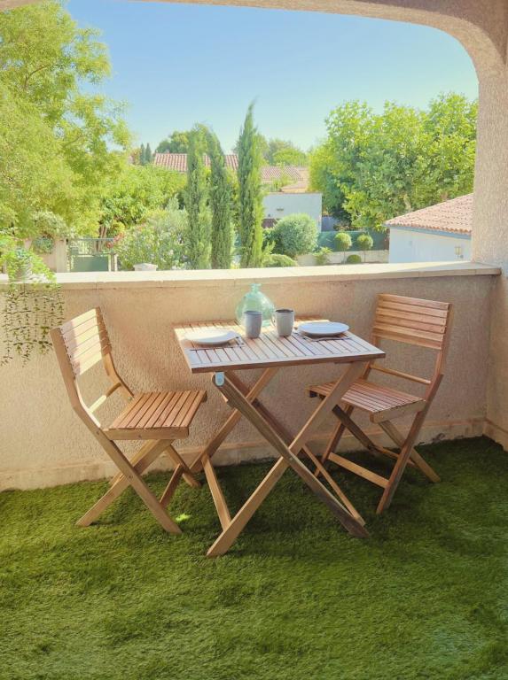 une table et deux chaises assises sur une terrasse dans l'établissement ''' Impasse d'un Instant ''' 8min Aix - Clim & Parking, à Venelles