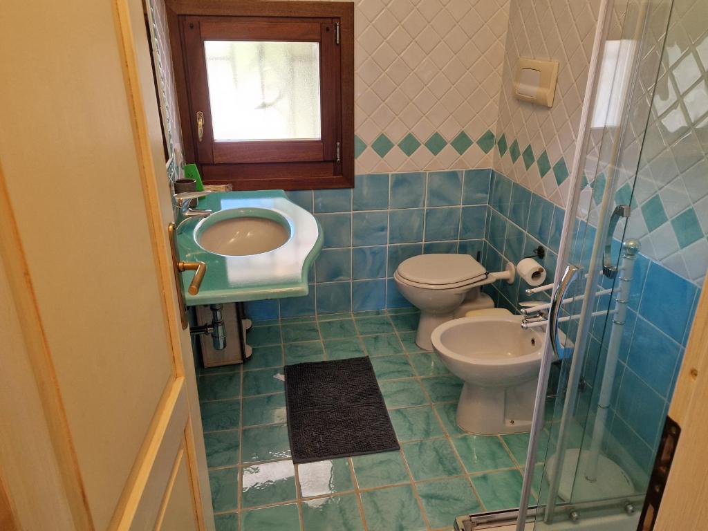 a bathroom with a toilet and a sink at Appartamento le querce in Vaccileddi