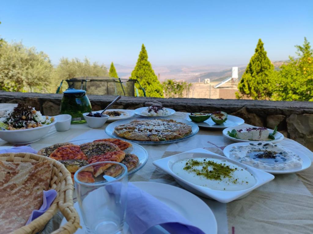 Una mesa con muchos platos de comida encima. en Sanabl Druze Hospitality, en Ein Kinya