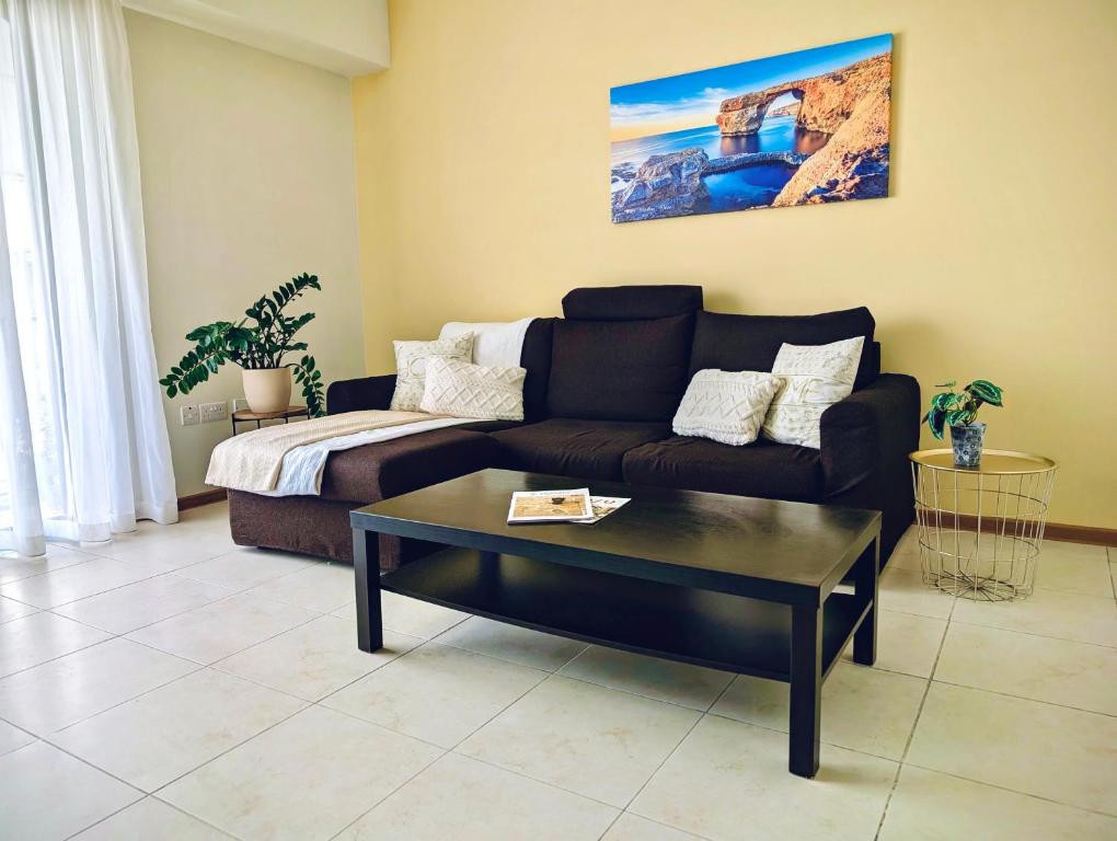 a living room with a couch and a coffee table at Sunset Haven Manikata - Walking distance to Golden Bay in Manikata