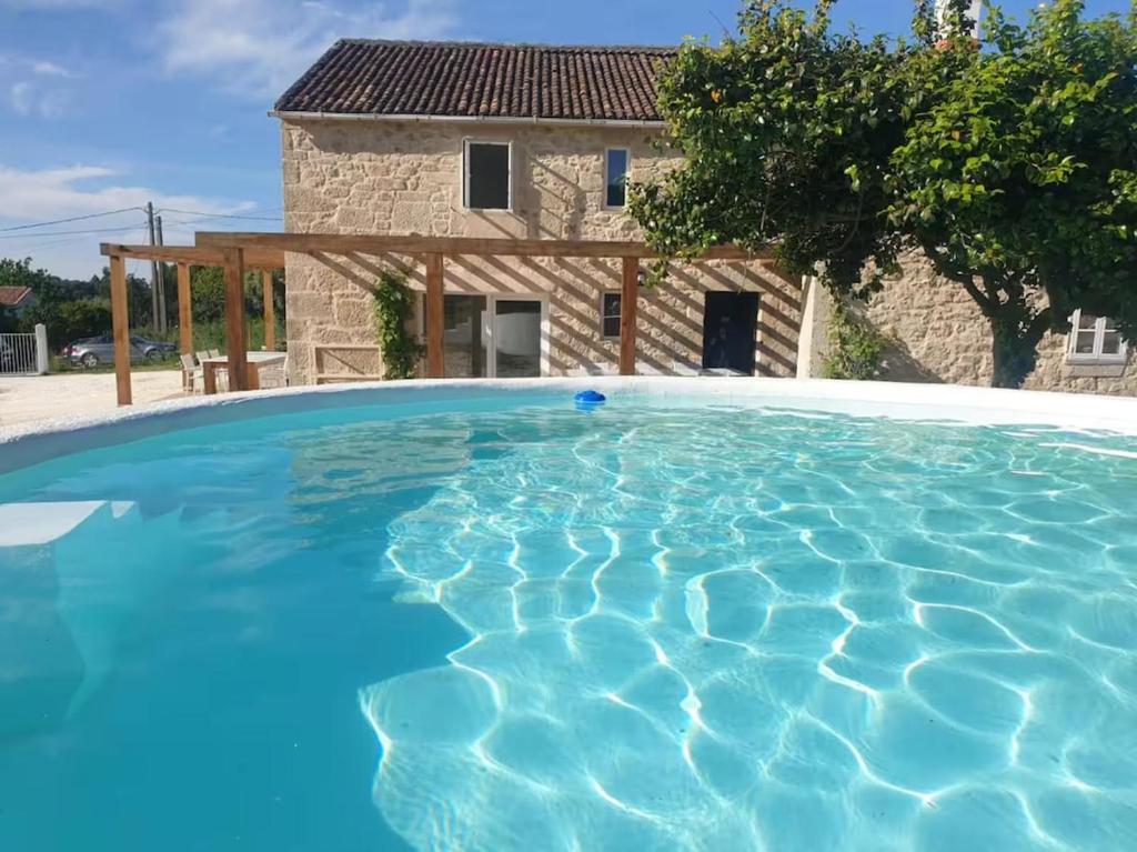 Una gran piscina azul frente a una casa en Casa Castro, en Lamas