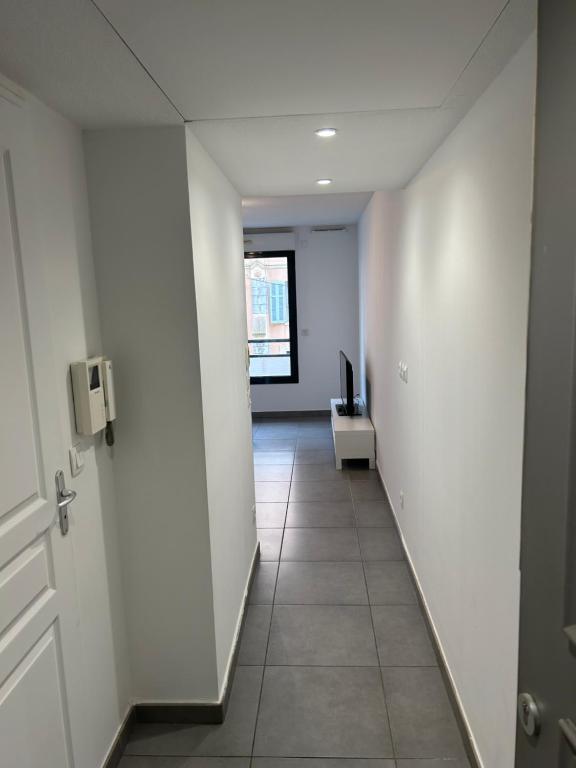 un couloir vide avec une porte et une chambre dans l'établissement studio confortable, à Cannes