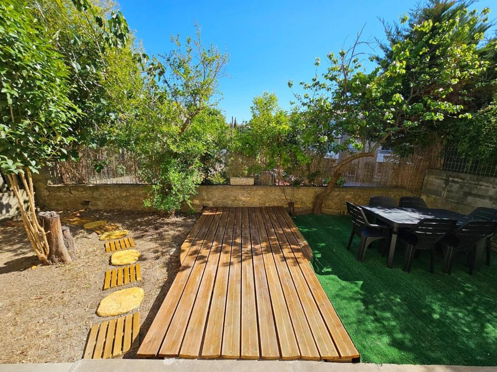 une arrière-cour avec une table et des chaises ainsi qu'une terrasse en bois dans l'établissement L'Horizon de la cité, à Carcassonne