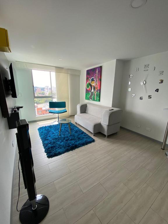 a living room with a couch and a clock on the wall at Apartamento in Pereira