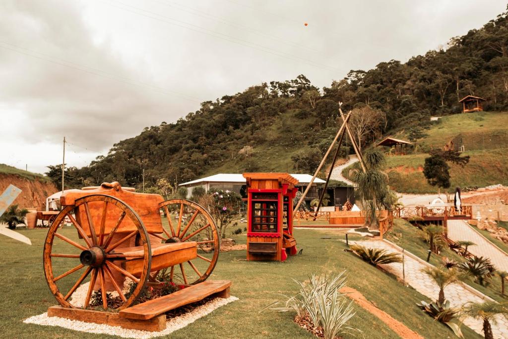 a wooden cart sitting on top of a grass field at Turisfri Resort in Nova Friburgo