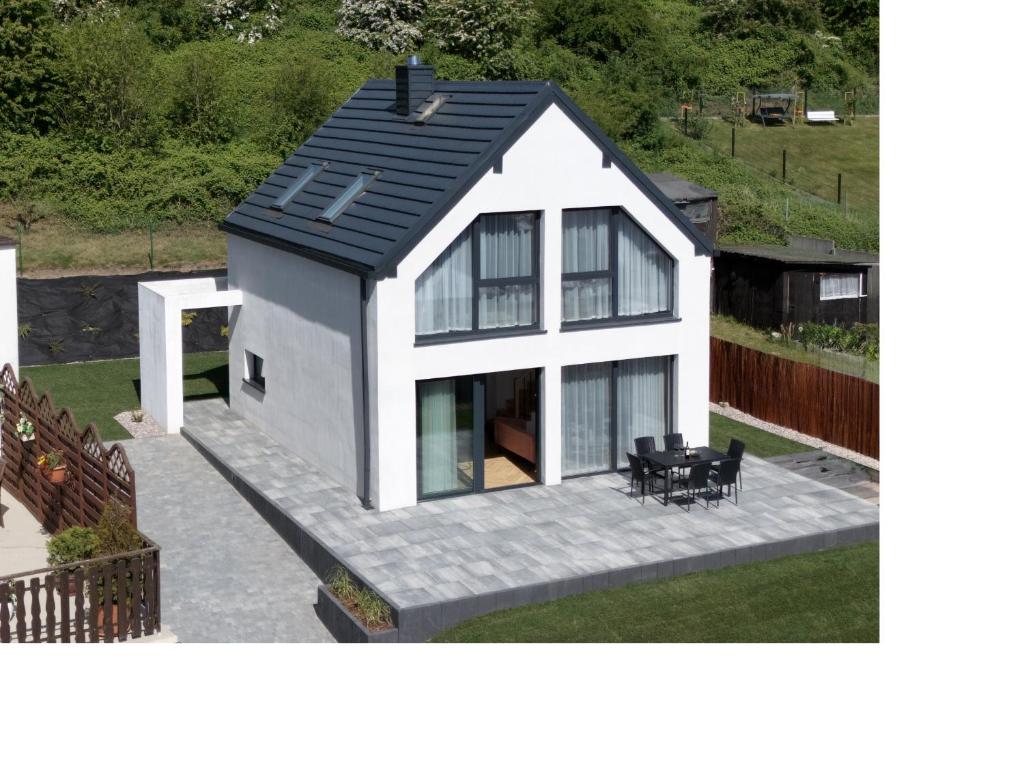 a small white house with a black roof at Domek na Rybackiej in Swarzewo