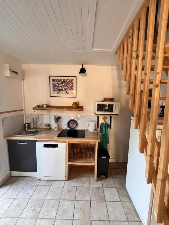 une cuisine avec un évier et un comptoir dans l'établissement Charmante maisonnette, à La Celle-sous-Gouzon