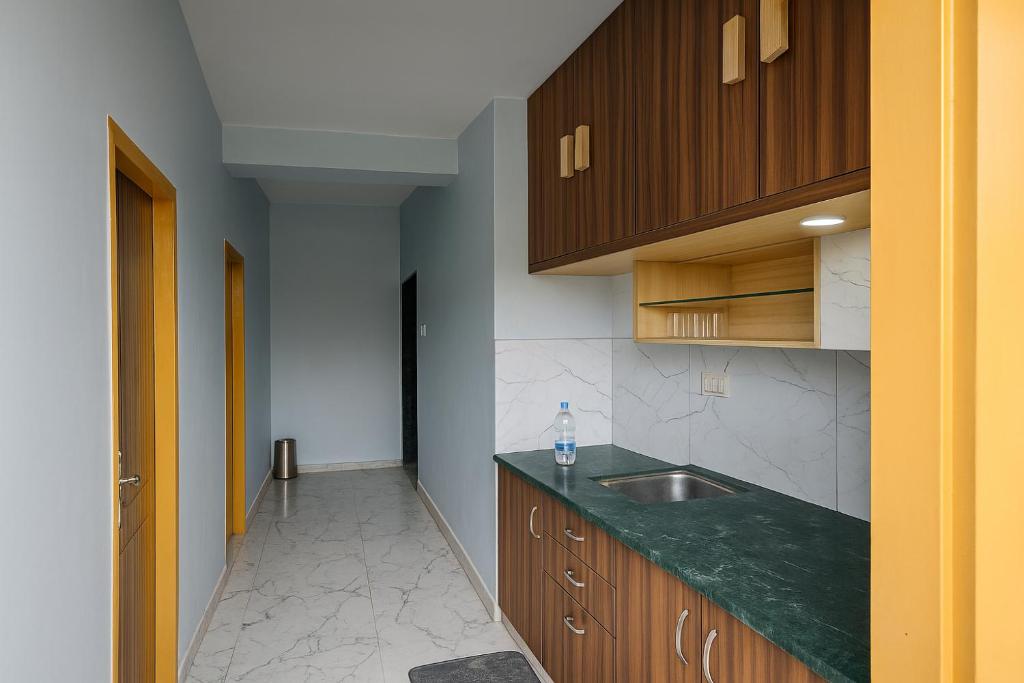 una cucina con piano di lavoro verde e lavandino di Rajnandani Palace Ayodhya - Modern Stay Near Ram Mandir with Free Parking a Ayodhya